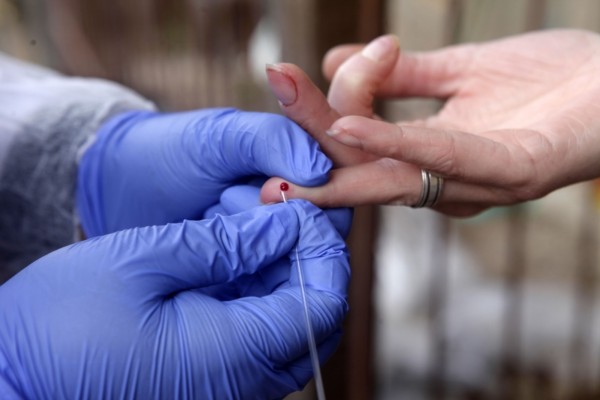 A partir de um único furo na ponta do dedo do participante, os entrevistadores coletam as amostras tanto para o teste rápido quanto para o novo