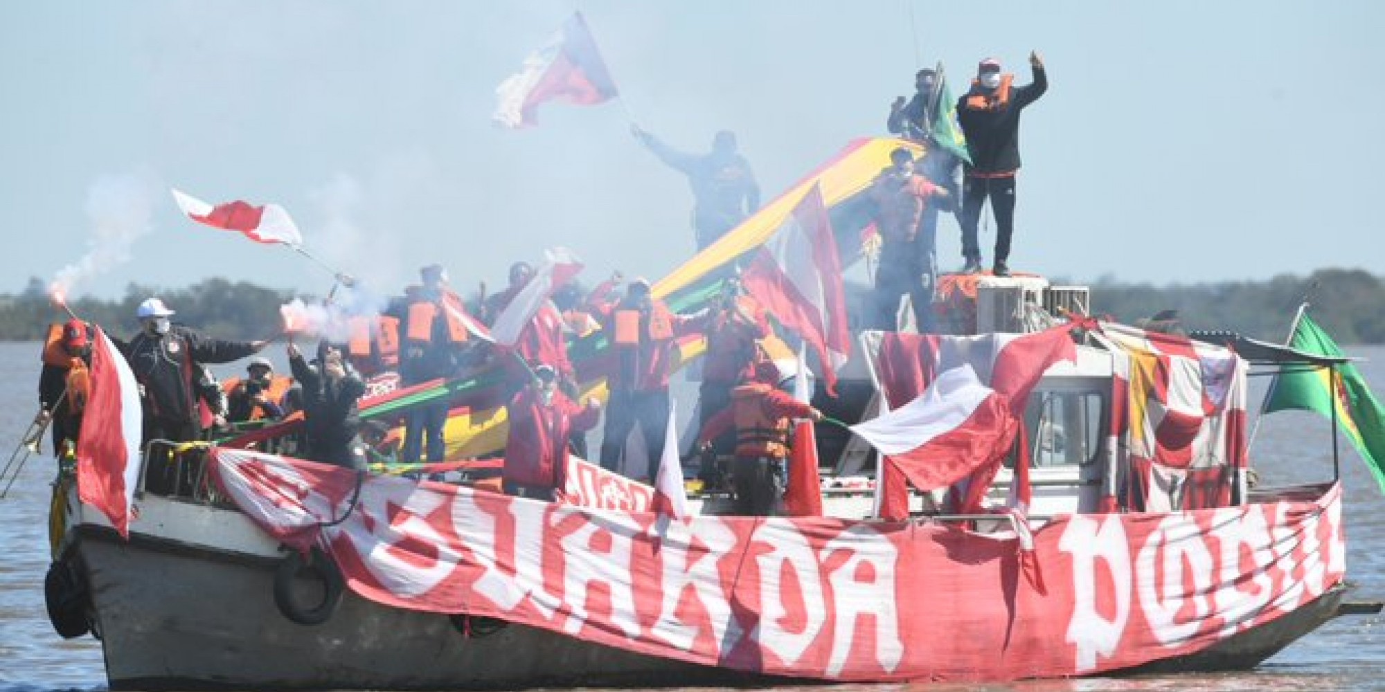 Torcedores se aproximaram do local de treinamento com um barco Torcedores se aproximaram do local de treinamento com um barco